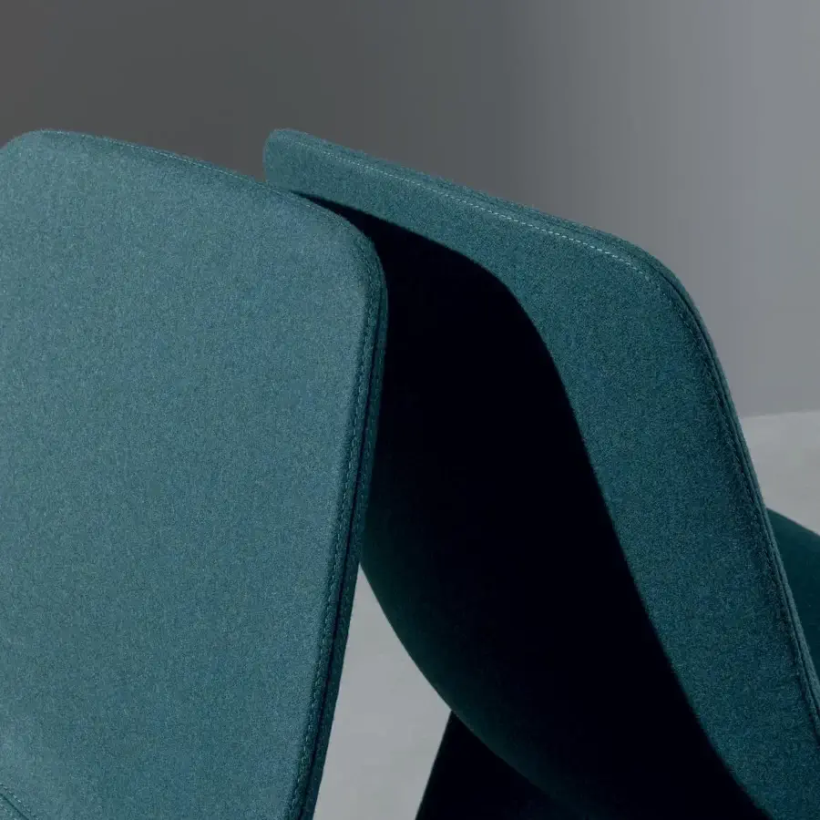 Lavish Bonaldo Agea chair with a curved seat and monolithic steel base upholstered in solid teal textile with meticulous stitching