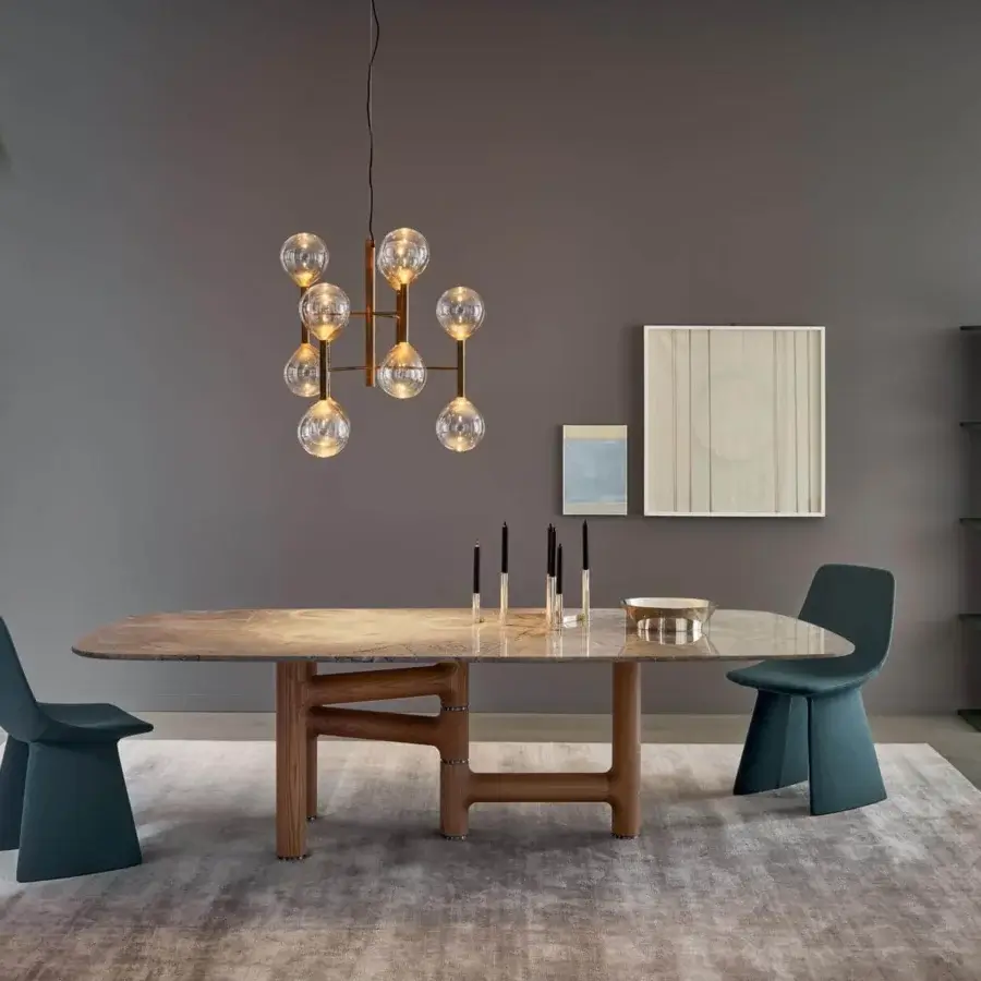 Superior Bonaldo Pivot table with asymmetric solid wood base and refined metal inserts, displaying a light-toned stone-like pattern tabletop