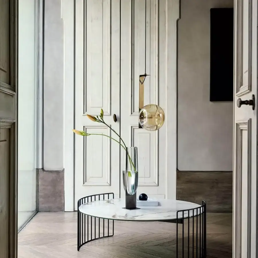 Superior Bonaldo Harpe coffee table with curved black metal base supporting a round marble-effect white surface