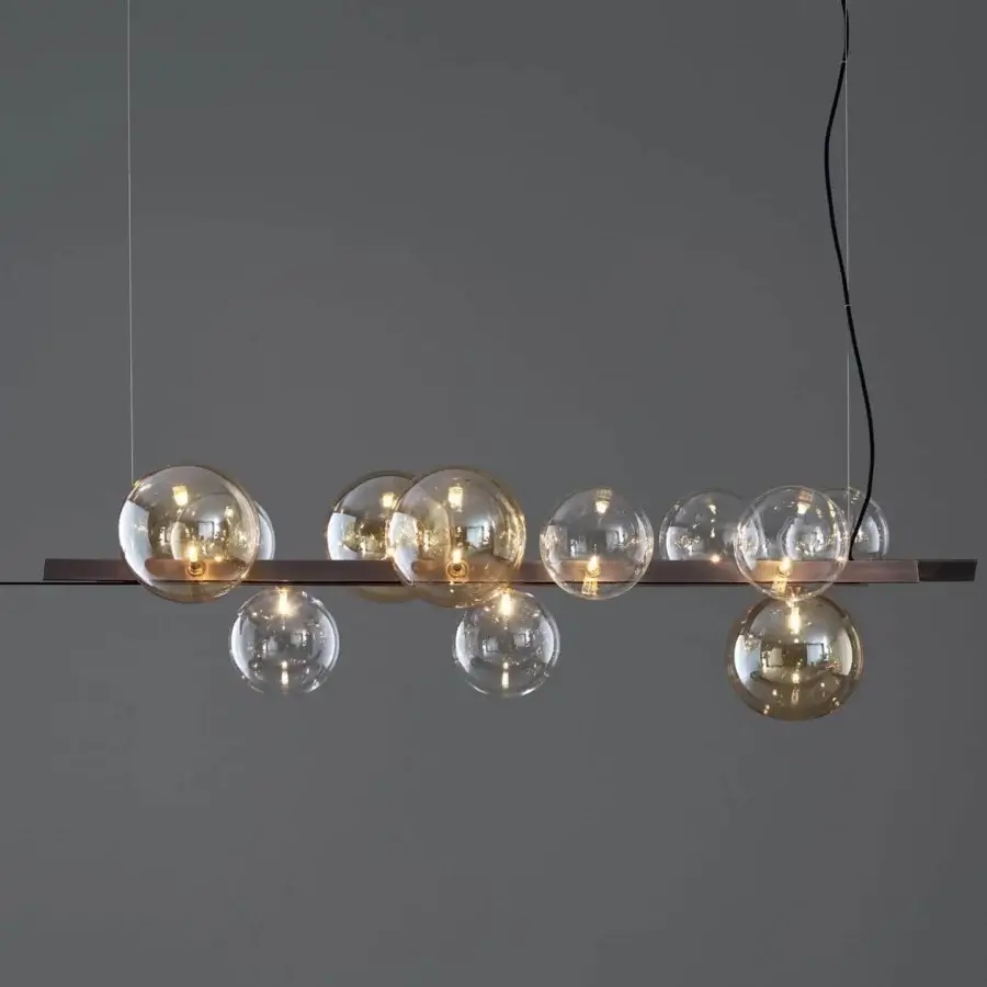 Elegant Bonaldo Bon Ton suspension lamp with a dark bronze metal frame supporting transparent and amber glass globes in a balanced arrangement