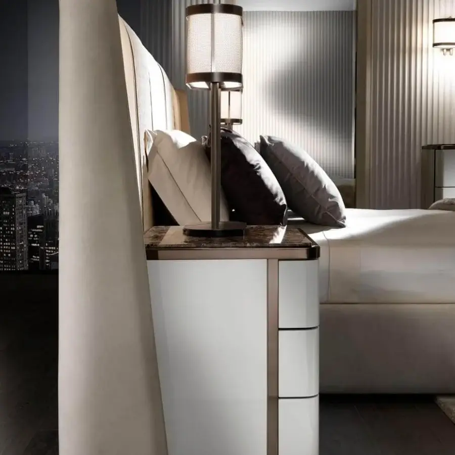 Distinguished DV Home Collection Coco Maxi bed with light beige textile and curved headboard complemented by a white nightstand with dark marble and bronze accents