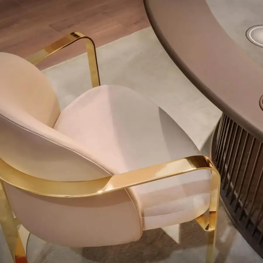 Superior Vismara Bell armchair with light peach textile and a glossy anodic gold metal frame