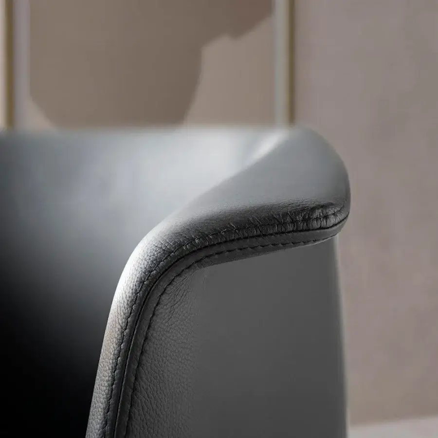 Elegant Presotto Milo armchair with curved silhouette and dark fine-textured upholstery on a five-point-star aluminum base