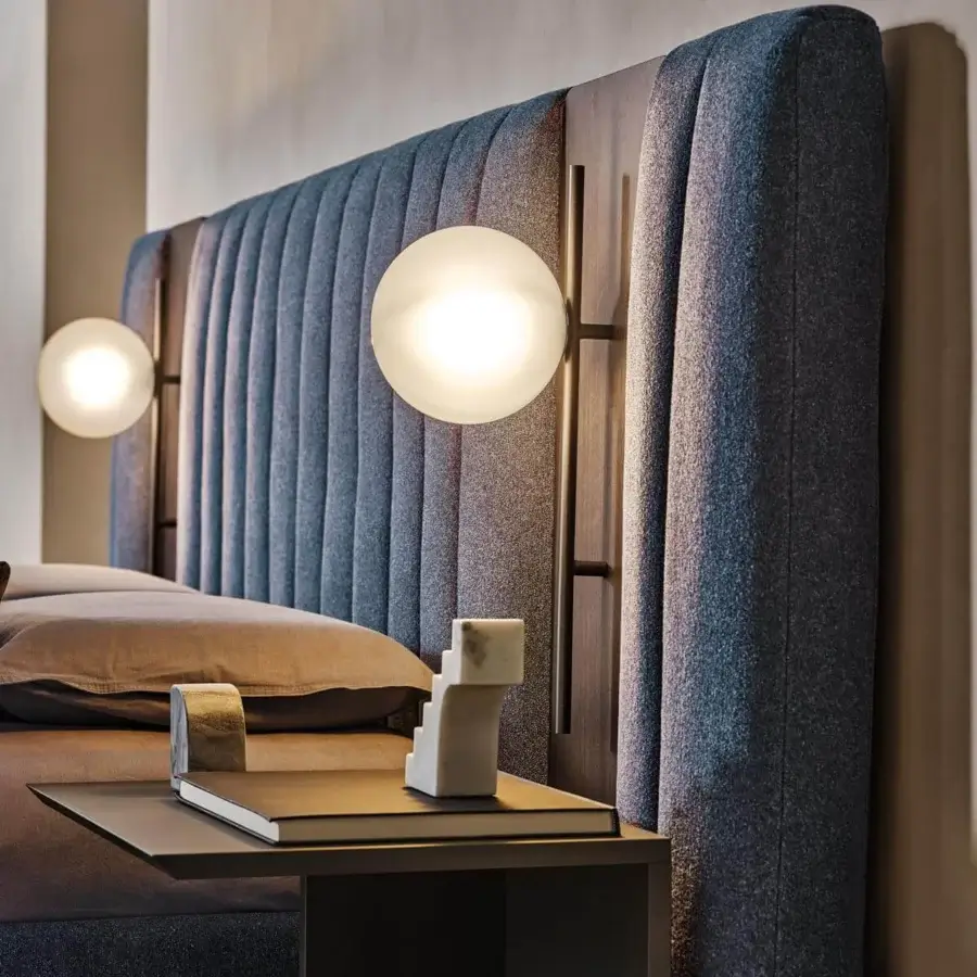 Lavish Ditre Italia Otello bed with geometrically segmented headboard upholstered in textured blue-gray and tan textiles with dark matte wood accents