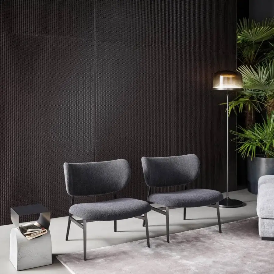 Elegant Bonaldo Noor lounge chair with curved backrest upholstered in uniform gray textile and dark finished metal legs