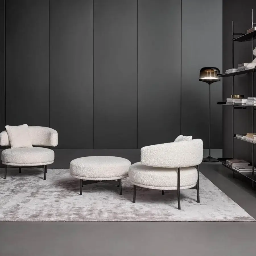 Lavish Bonaldo Neuilly lounge chair with rounded form upholstered in textured light cream fabric and dark matte metal frame