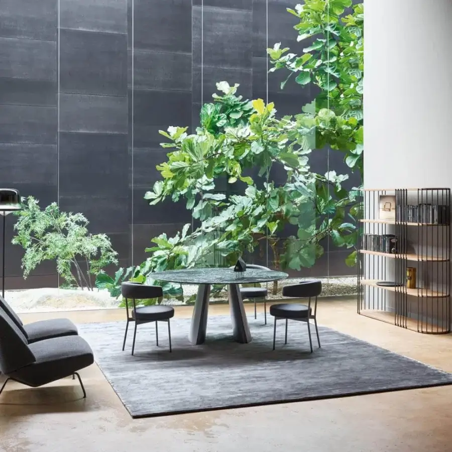 Refined Bonaldo Torii table with rigorous ceramic top and metal base exhibiting tonal variations in a cool gray matte finish