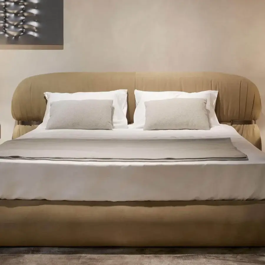 Superior Rugiano Fandango bed with enveloping lines upholstered in warm beige leather and bronzed brass metal frame