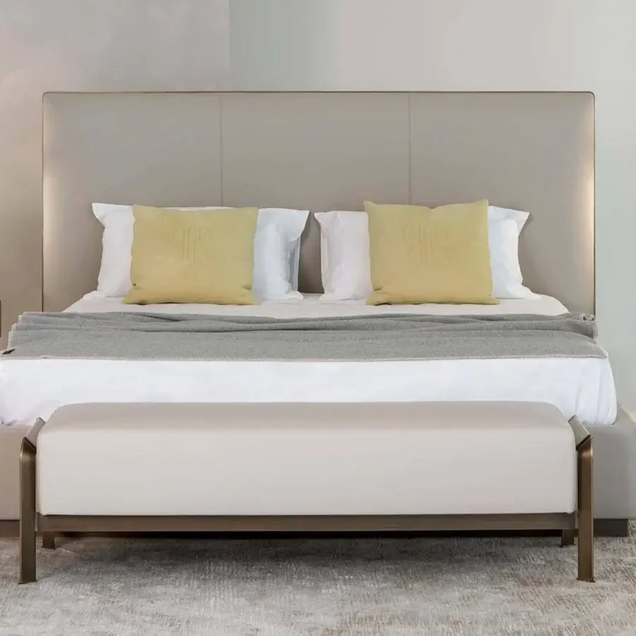 Superior Rugiano Falcon Slim bed with wide headboard and low frame upholstered in light beige textile with bronze brass finish