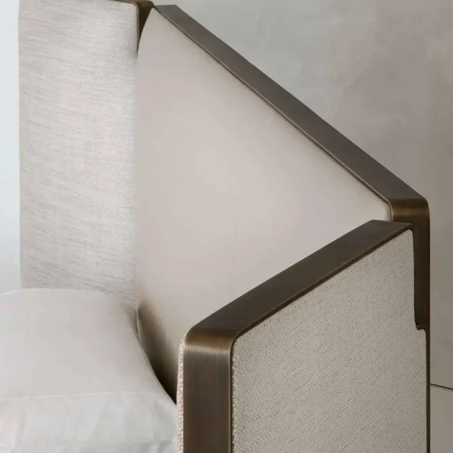 Captivating Rugiano Falcon bed with a geometric headboard upholstered in light neutral textile and bronze brass finish