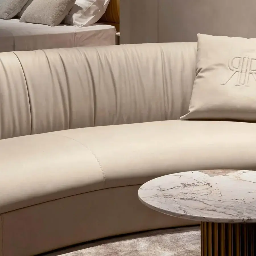 Exceptional Rugiano Fandango sofa with a continuous form, light beige leather upholstery and bronze brass metal band