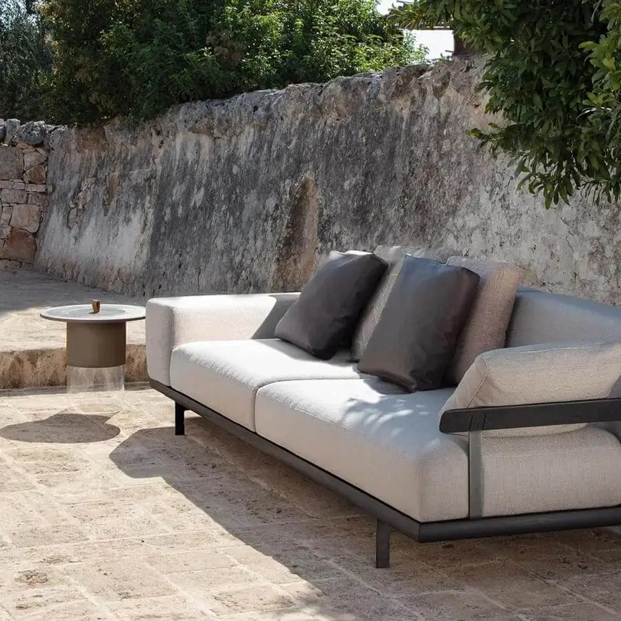 Exclusive Talenti Allure sofa with dark metal frame, light beige cushions and dark-toned wood accents built with brown leather pillows