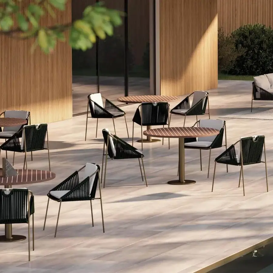 Refined Rugiano Wood Bistrot table with a round wood top and outdoor bronze central metal base in a medium brown hue