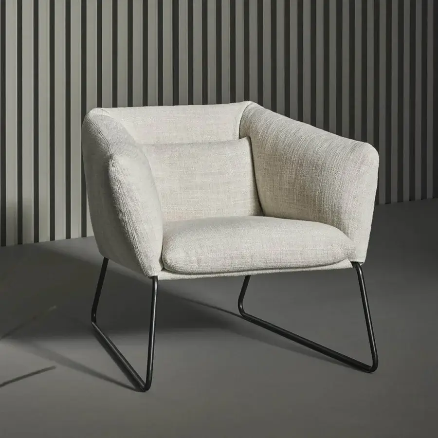 Elegant Bonaldo Nikos low lounge chair in textured beige fabric with a sleek dark metal sled base and matte finish