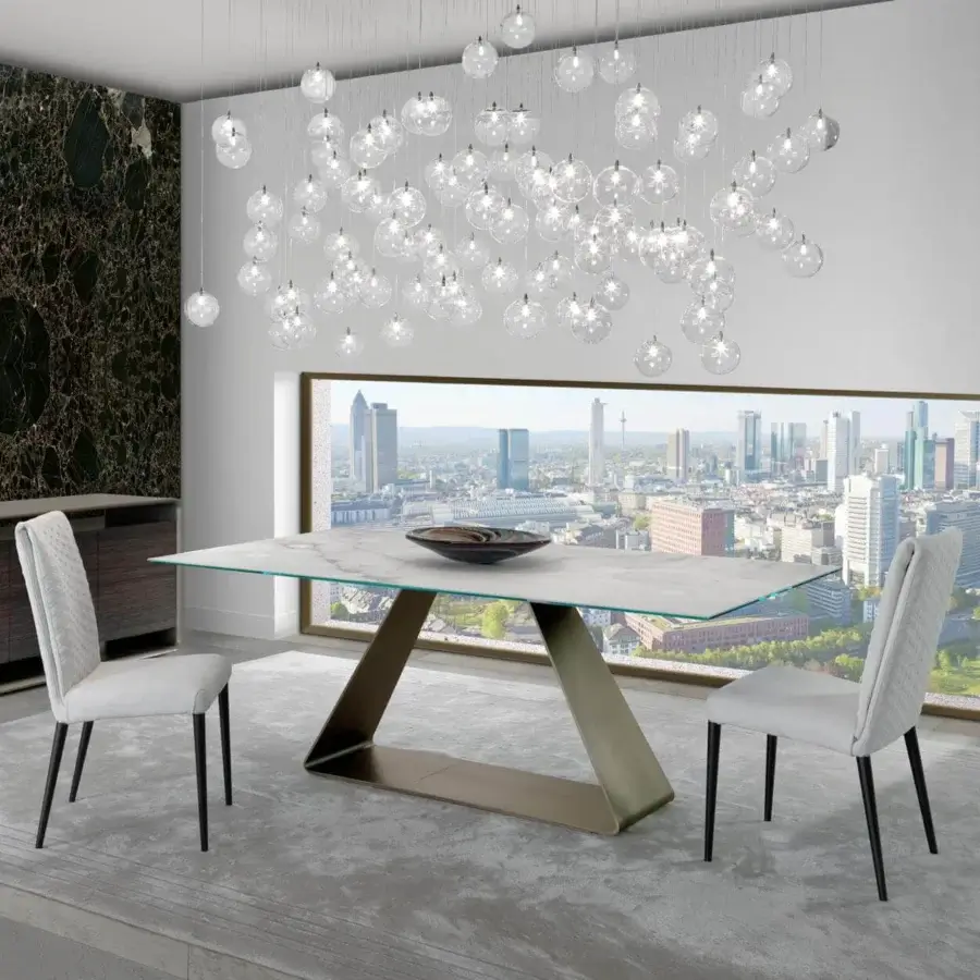 Refined Reflex Oh table with bent metal base in satin bronze and expansive Marble glass tabletop