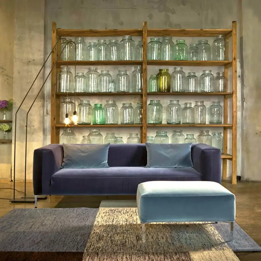 Refined Verzelloni Fold sofa with muted purple textile upholstery and lighter blue-grey cushions exhibiting distinctive envelope stitching and chrome cast feet