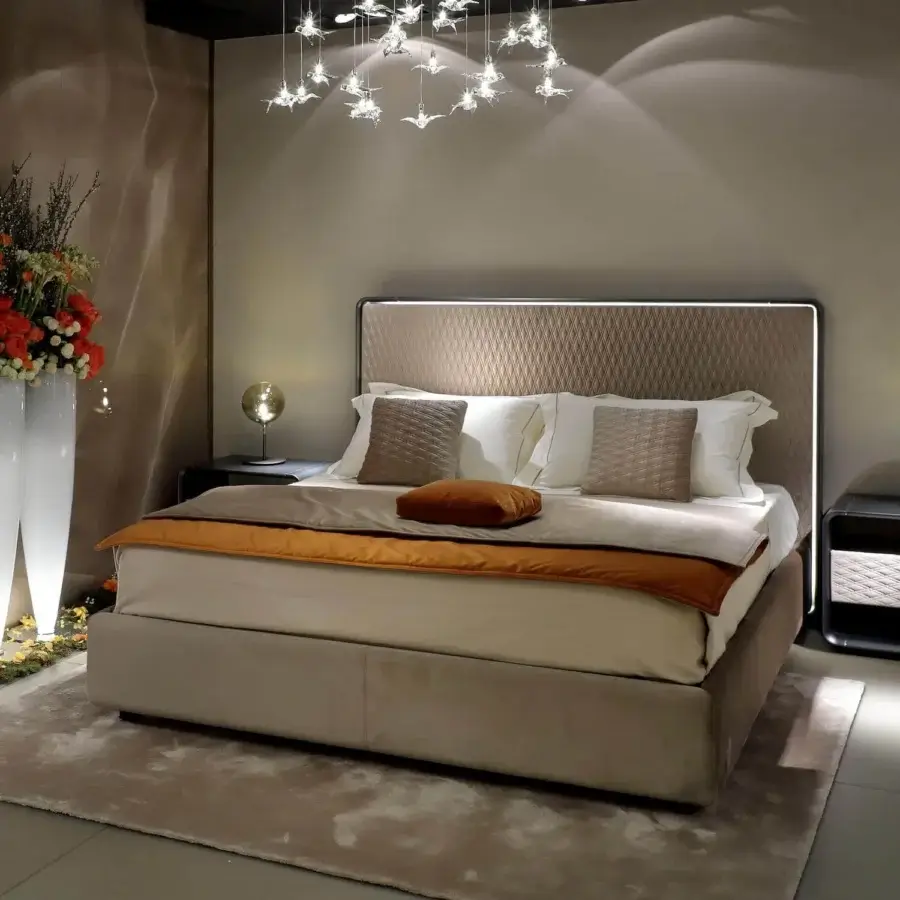 Exclusive Reflex Oh bed crafted with a quilted padded headboard in neutral beige fabric and Bronze finish wood framing with subtle lighting