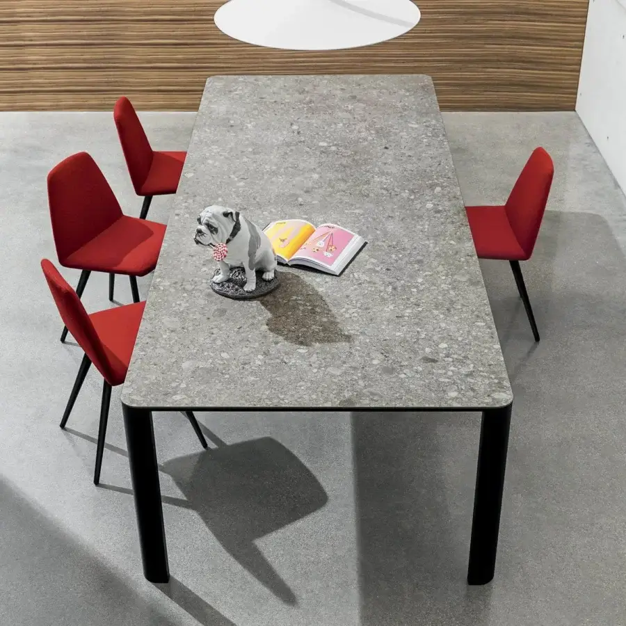 Refined Sovet Italia Kodo table with aluminum structure and speckled ceramic tabletop in a neutral gray tone with a matte finish