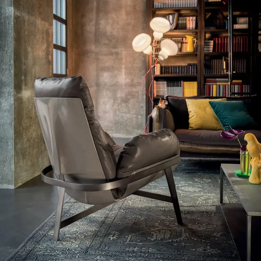 Architectural Arketipo Jupiter lounge chair with gray metal arch and gray-brown leather-like seat offering dynamic lightness