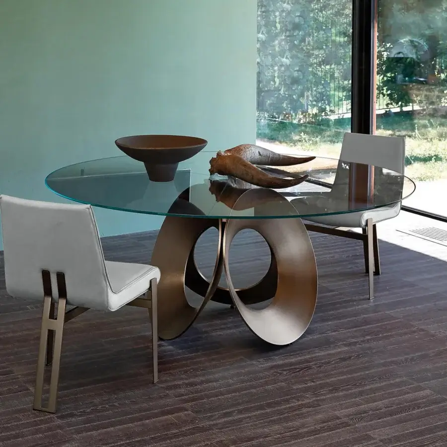 Superior Arketipo Oracle table with a circular glass top and bronze-like metal base resembling the flower of life
