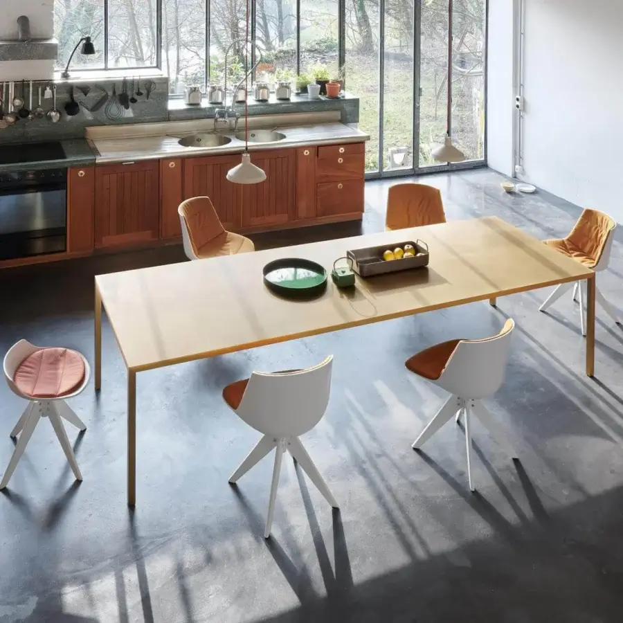 Elegant MDF Italia Tense table with light golden rectangular surface and slender legs in brass plate with matt brushed finish and acrylic cover