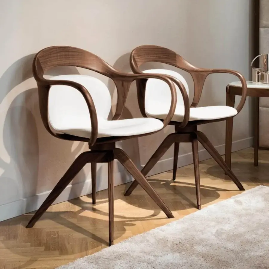 Elegant Giorgetti Norah armchair with curved silhouette and pristine white fabric upholstery crafted in canaletto walnut with bronze inserts