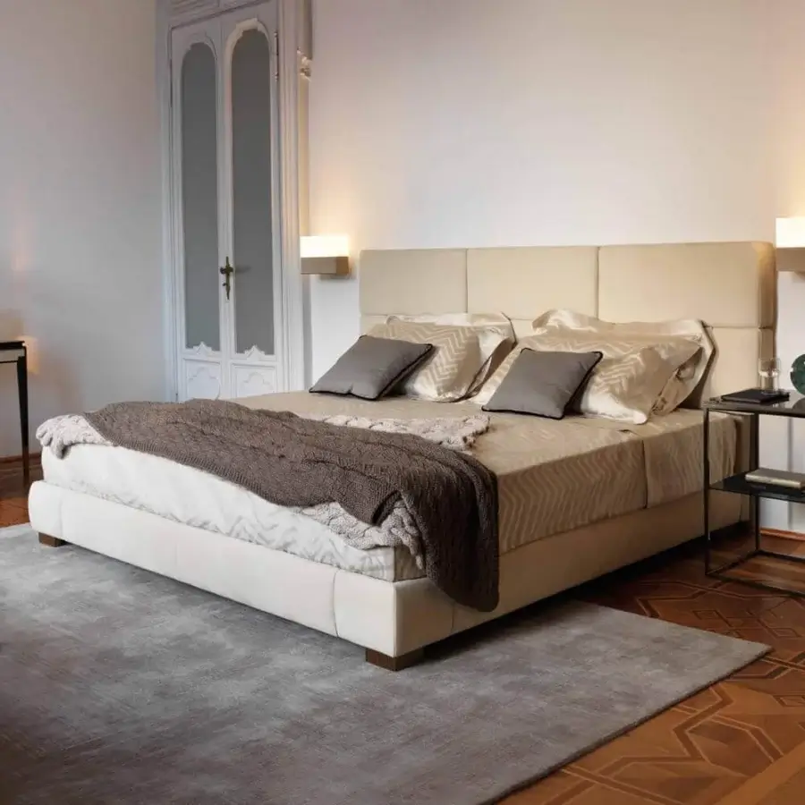 Elegant OAK Moscova bed upholstered in light beige textile with quilted headboard and dark nickel metal feet