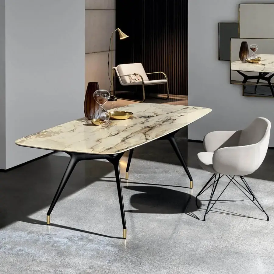 Elegant Sovet Italia Arkos table with beige and brown artificial marble top and sleek black X-shaped legs with gold-toned feet