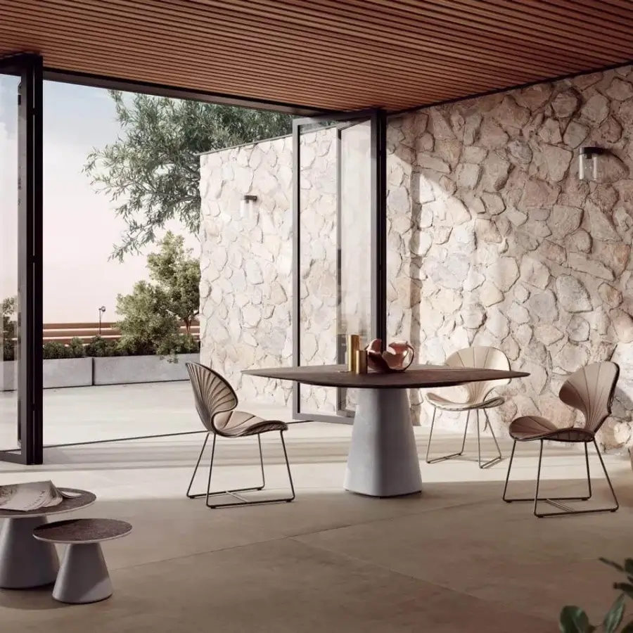 Comfortable Royal Botania Ostrea chair with a black metal frame and beige textile seat, featuring a delicate fan-like backrest and angled legs for outdoor dining