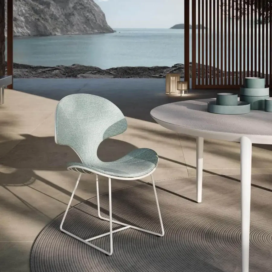 Comfortable Royal Botania Ostrea chair with a light turquoise textile seat and backrest, white metal frame and a darker accent for outdoor dining.