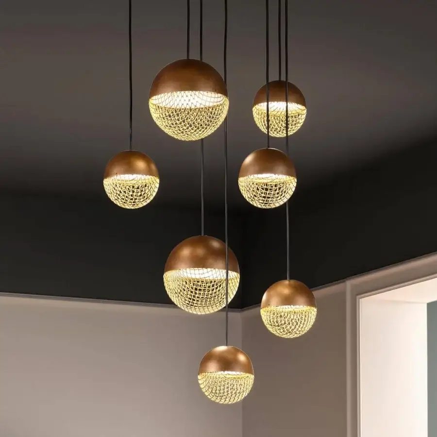 Distinguished Masiero Iglù suspension lamp with an elegant metal mesh diffuser in matt gold finish, creating a captivating pattern of light and shadow