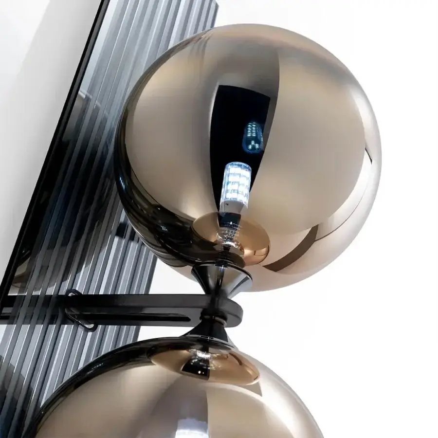 Elegant Reflex Bulles XL wall lamp with smoked mirror glass support and glossy bronze spheres casting warm light