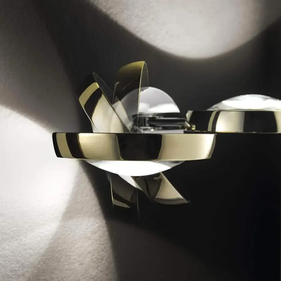 Elegant Lodes Nautilus wall lamp with reflective gold metal panels creating a layered sculptural effect and soft illumination