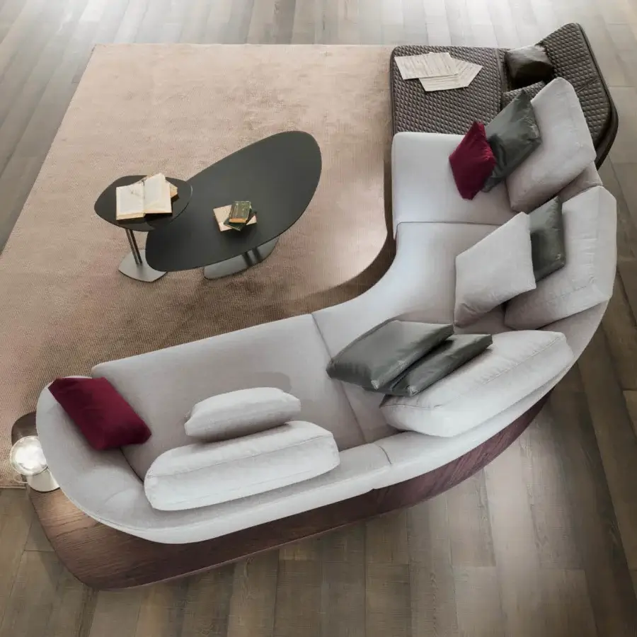 Distinguished Reflex Segno sofa chaise lounge upholstered in light gray fabric with burgundy and dark gray cushions and a Canaletto Walnut platform with bronze metal legs