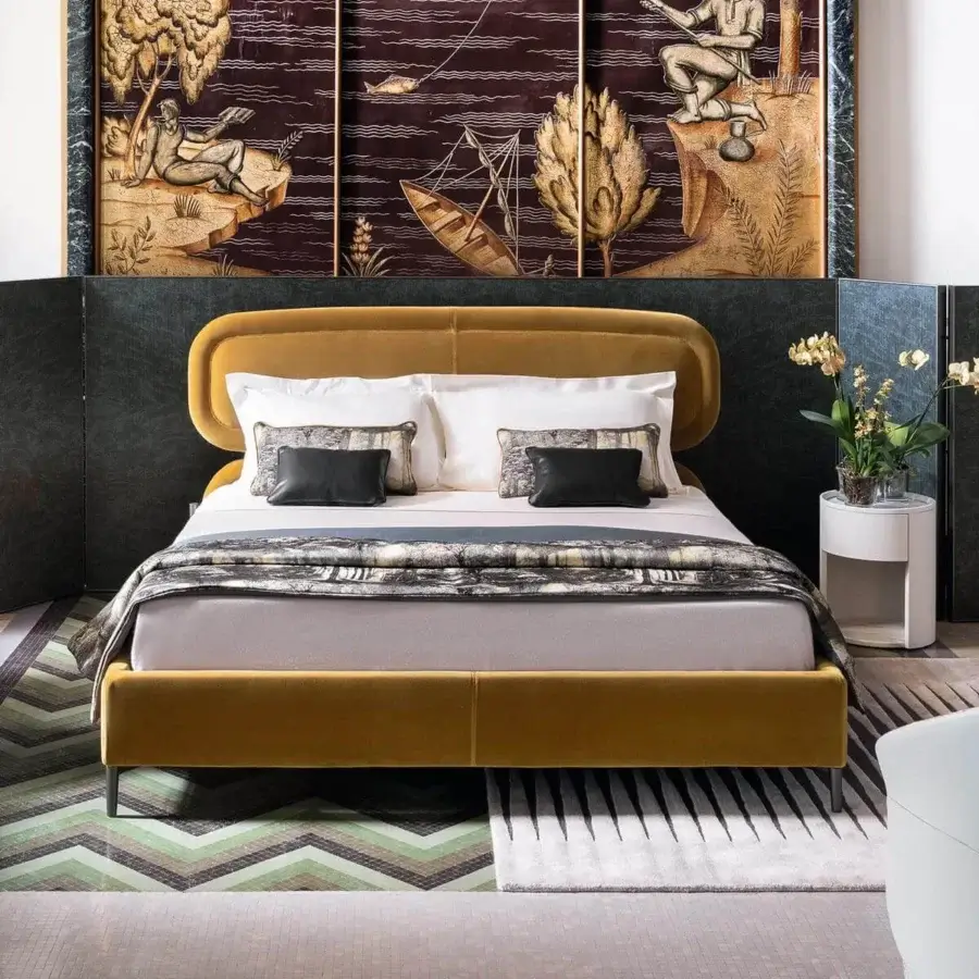 Elegant Giorgetti Vibe bed with curved mustard-yellow upholstery, dark metal legs and Canaletto walnut nightstand tops