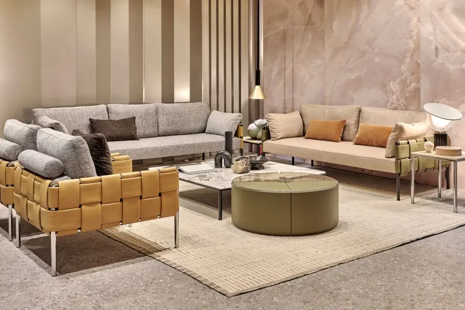Distinguished Turri Ratio lounge chair with soft gray cushions and woven tan leather exterior with polished metal legs