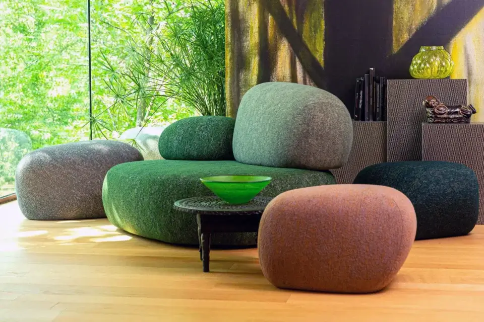 Moroso Pebble Rubble lounge chairs, green and gray fabric, modular rounded forms, with dark wood coffee table and reddish ottoman in modern interior.