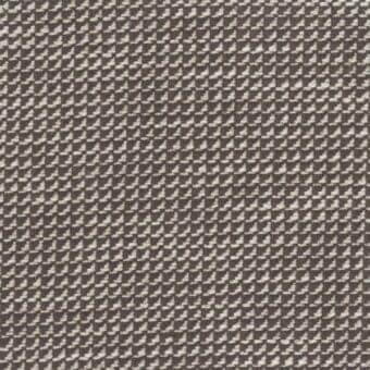 Woven fabric sample, muted brown and off-white, irregular clustered motifs, dense matte texture, Mariani brand label visible.