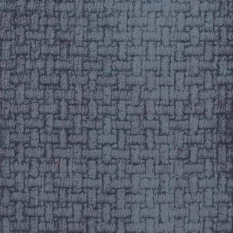 Dark gray-blue textured fabric sample with irregular, stone-like pattern; tightly woven with tonal variations and a small orange speck.