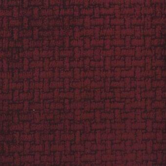 Burgundy fabric texture with a dense, nubby weave and interlocking geometric pattern; studio sample displaying Mariani “Le Fate” textile.