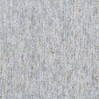 Light gray woven fabric texture with granular surface, speckled pattern, and small dried leaf; wool-blend material sample named “z trieste”.