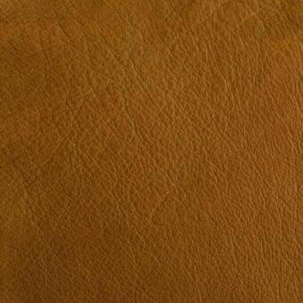 Mariani Leather pa modigliani, golden-brown full-grain leather texture with dense, irregular grain pattern and smooth, glossy finish.