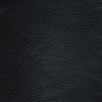 Black leather texture sample with irregular grain, matte finish, and imprinted Mariani "caracara" label; dense, tightly-woven material.