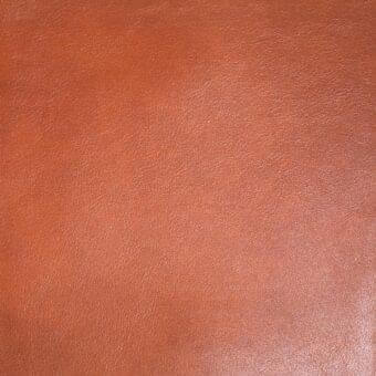 Mariani leather texture sample in reddish-brown, displaying a subtle granular pattern and matte finish with consistent color variation.