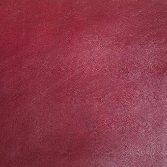 Deep red leather texture sample, “px platano,” shows a subtly pebbled, matte surface with tonal variations and consistent grain throughout.