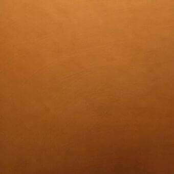 Earthy gradient texture displaying warm orange tones, transitioning from saturated to muted, with a smooth, porous surface and subtle grain.