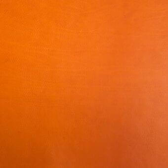 Vegetable-tanned saddle leather texture in orange with mottled grain, displaying a smooth sheen and subtle tonal variations for durability.