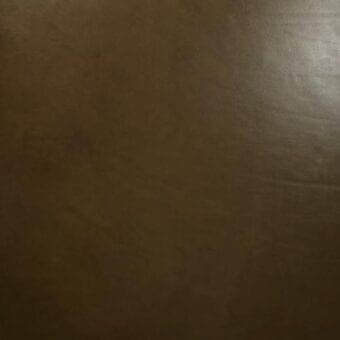 Vegetable-tanned saddle leather swatch in warm brown with subtle texture, matte finish, and diffused lighting, sample Nevada NE13.