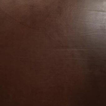Vegetable-tanned saddle leather in dark brown with a textured grain, displaying linear creases and natural markings; Mariani Nevada NE6 leather.