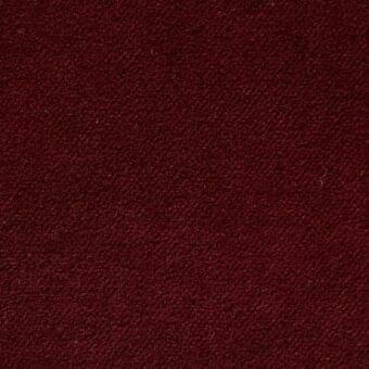 Burgundy velvet fabric sample with dense pile and granular texture, displaying consistent color and subtle tonal variations under even lighting.